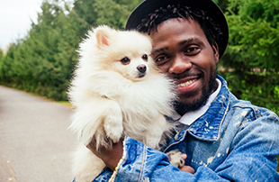 man hugging his fluffy spitz park