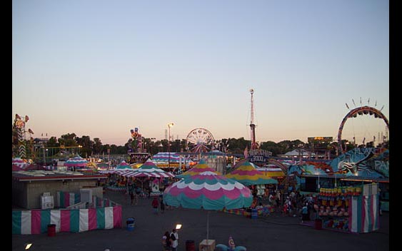 A carnival skyline featuring rides booths