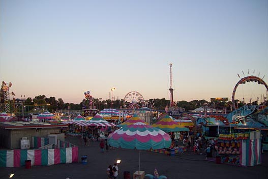 A carnival skyline featuring rides booths
