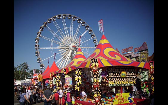 A giant ferris wheel looms over midway prize games