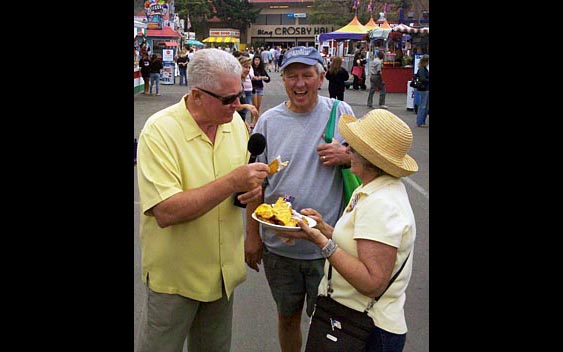 Huell Howser samples a fairgoer's lunch. San Diego County Fair, Del Mar