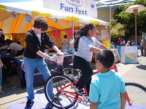 Fairgoers blend their own smoothies using a bicycle-powered blender - green never tasted so good! Marin County Fair & Exposition, San Rafael