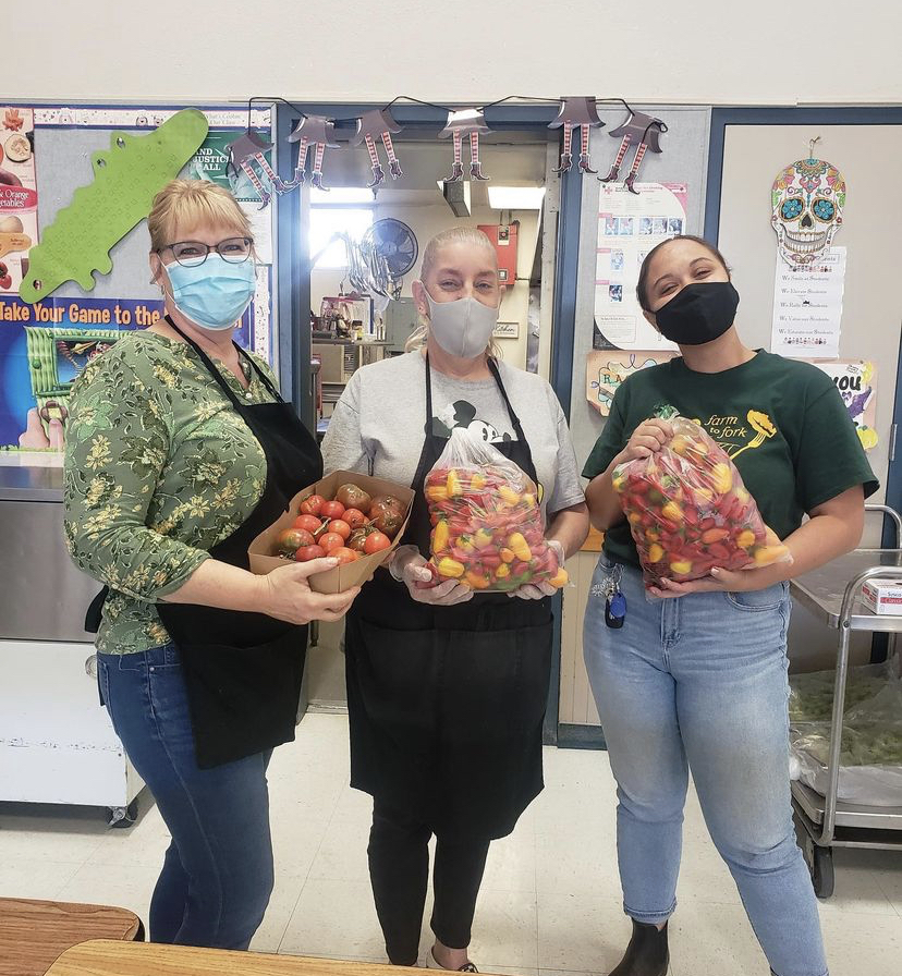 People holding peppers and tomatoes