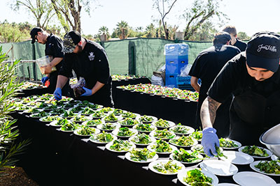 Green salads being prepared by chefs
