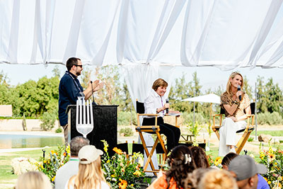 Speakers on a stage address event attendees