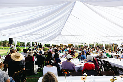 A white event tent filled with attendees