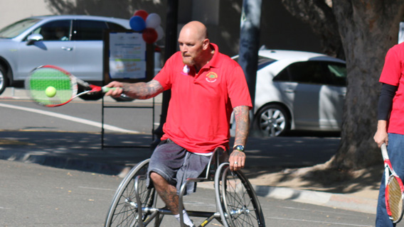 People playing adaptive tennis in wheelchairs