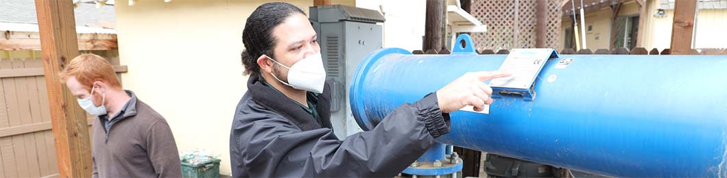 A worker inspects an irrigation pump